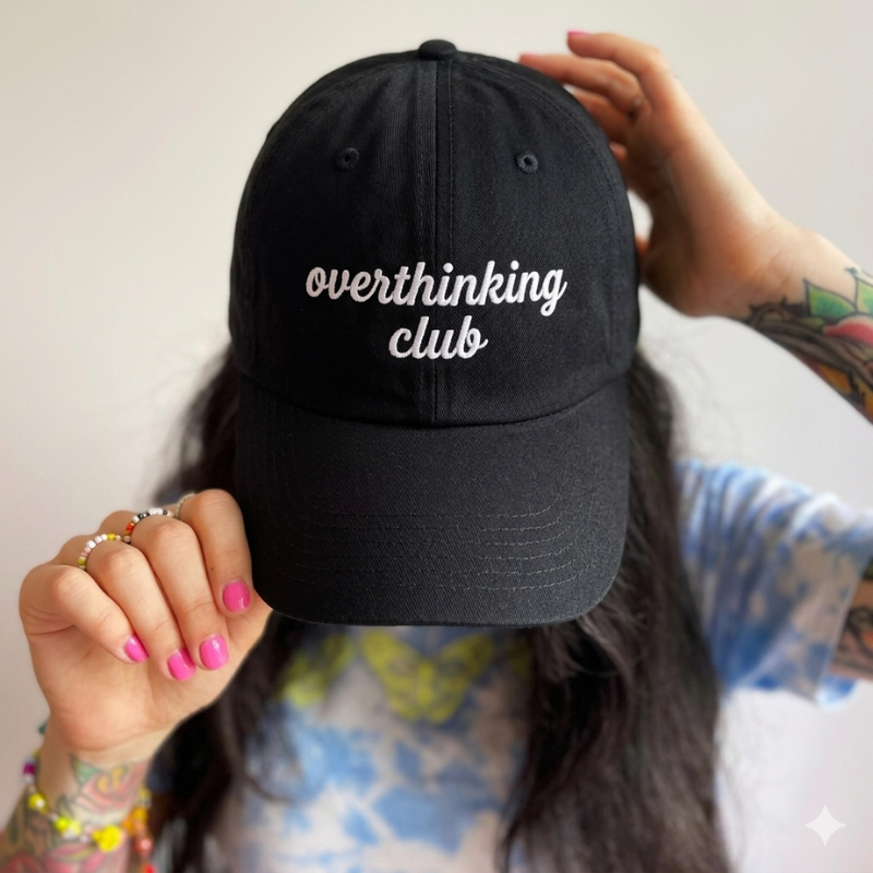 Črna kapa s šiltom z belim vezenim napisom "overthinking club" – unikatna kapa z zabavnim besedilom