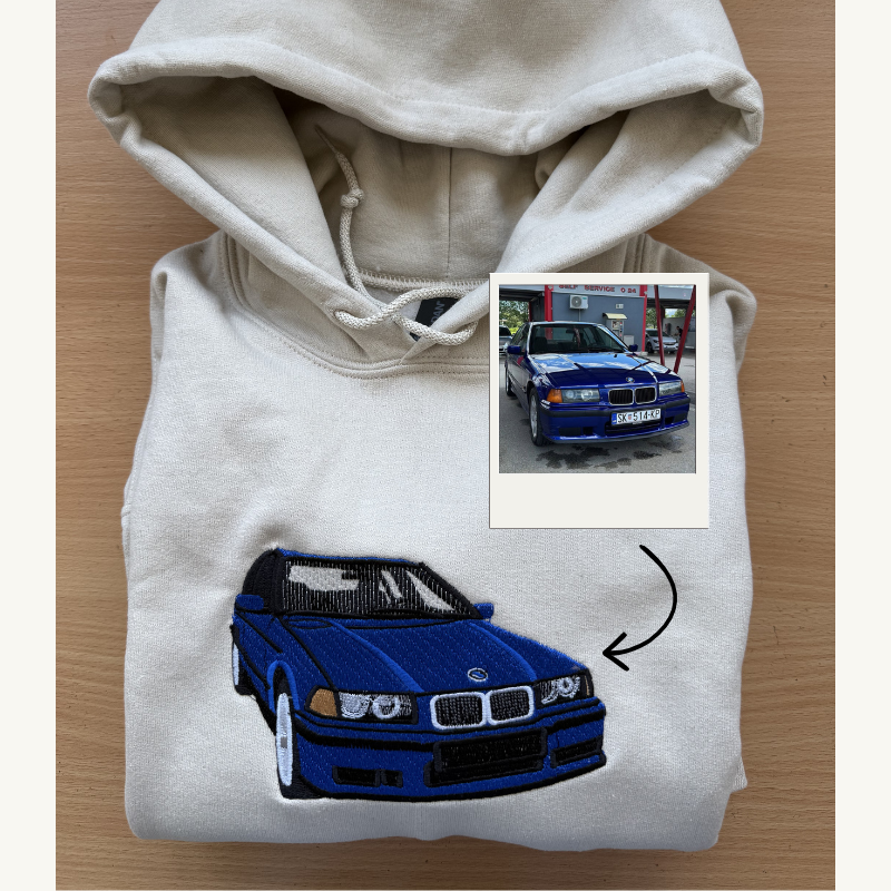 Detajl vrhunskega vezenja modrega avtomobila BMW E36 na bež puloverju, izdelanega po meri po originalni fotografiji.