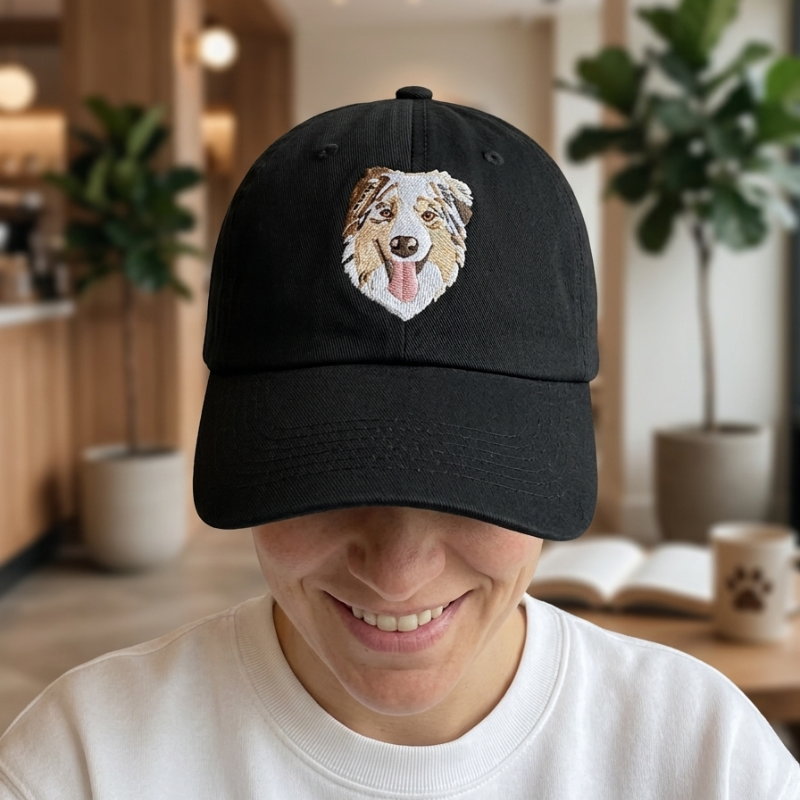 Črna kapa s šiltom z detajlnim vezenim portretom psa pasme avstralski ovčar. Unikatno vezenje po fotografiji.